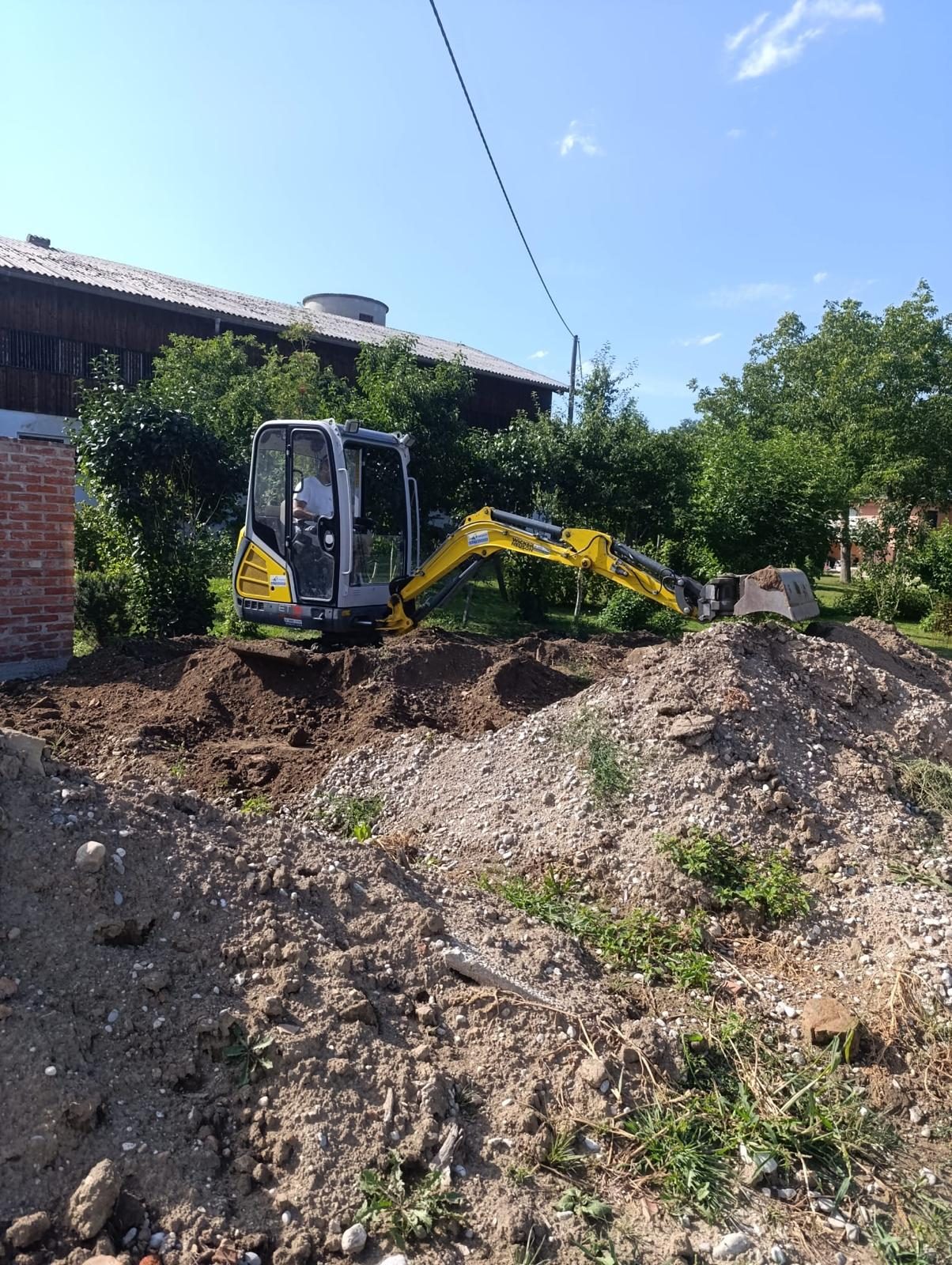 Baustelle mit ausgehobenem Erdmaterial neben der Poolgrube